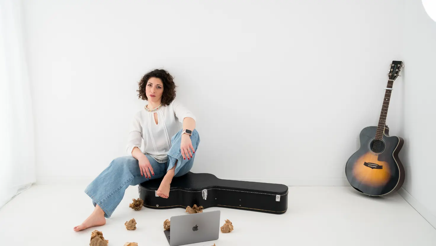 elisa, con chitarra seduta per terra e carta